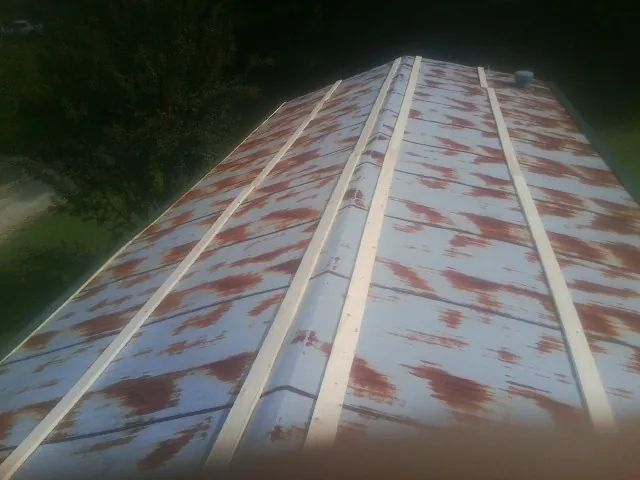 Rusted metal roof panels with new wood purlins before replacement — Storm Damage Roof Repair in Sadieville by Roofing Brothers