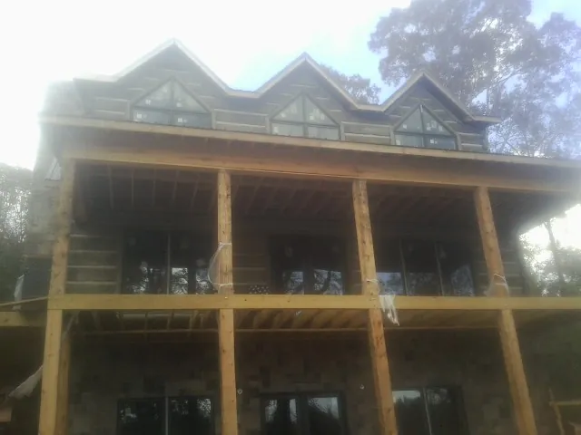 Dormers and porch framing on a large log home under construction — Roof Coating work by our crew in Sadieville