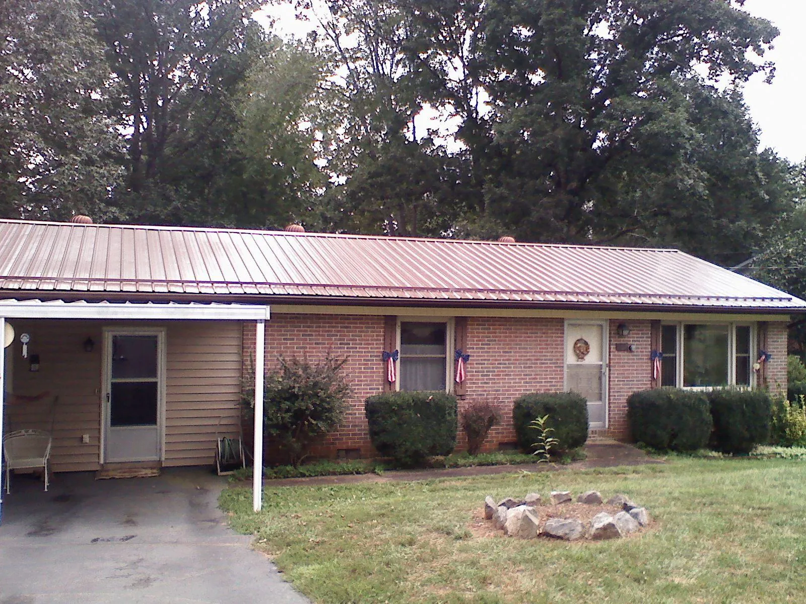 Bronze metal roof and carport on a brick ranch home — Roof Repair work by our crew in Sadieville